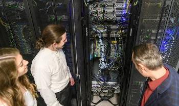 people look at an electrical cabinet with many wires coming out